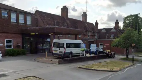 A Google Street View image of the hospital, which appears quite small and homely. A hospital van is parked in the main space at the front.