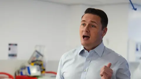 PA Media A man in a shirt in a hospital ward