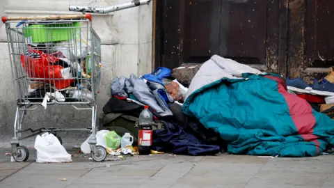 Reuters A homeless man sleeps in a doorway in Manchester city centre following the outbreak of the coronavirus disease 