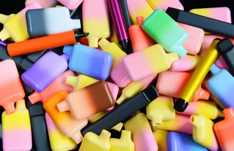 A pile of colourful vapes. 