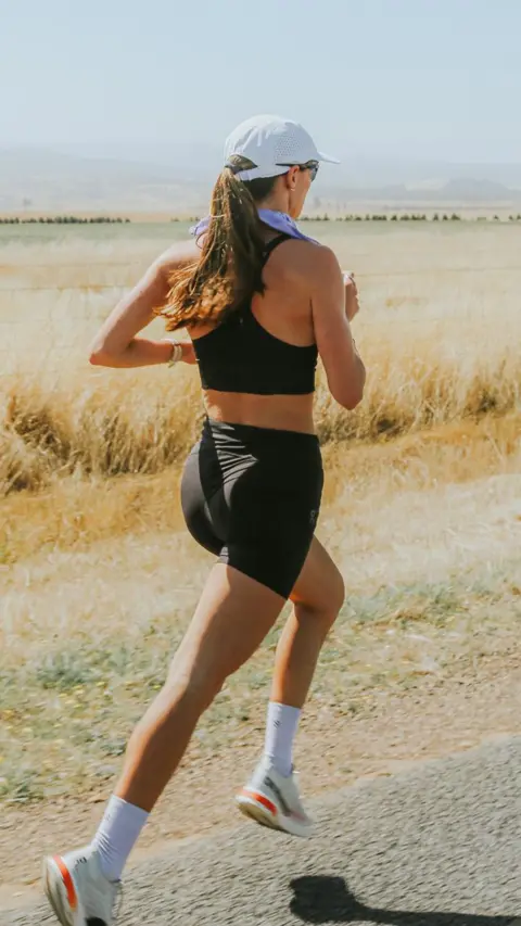 Megan Chapple Megan Chapple running in Tasmania. She is mid stride and looking forward. There are dry fields in the background.