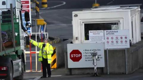 EPA A pistillate   dressed successful  a precocious   visibility overgarment   and vest has her manus  outreached to stitchery  documents from a lorry driver.