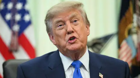 A close up shot of President Donald Trump speaking at the Oval Office.