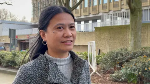 PA Media Apple Moorhouse, who has long black hair and is wearing a grey coat with grey jumper underneath, speaks outside Bradford Magistrates' Court.