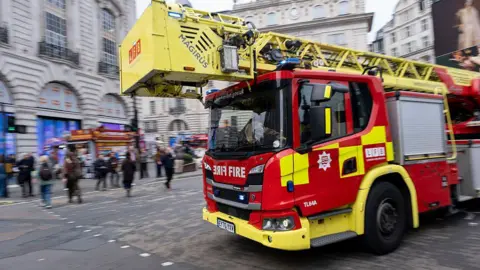 London Fire Brigade Simon Snorkel fire engine passes at speed in Piccadilly 