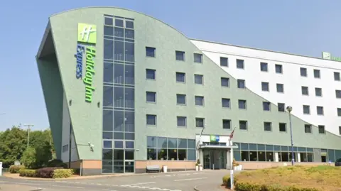 Google The Holiday Inn in Tamworth, a wave-shaped building with the words "Holiday Inn Express" on the side