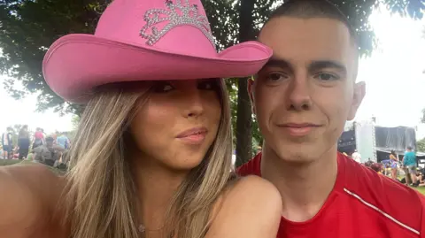 Jessica Gatherer wearing a pink cowboy hat and her boyfriend wearing a red t-shirt at TRNSMT festival in July 2023.