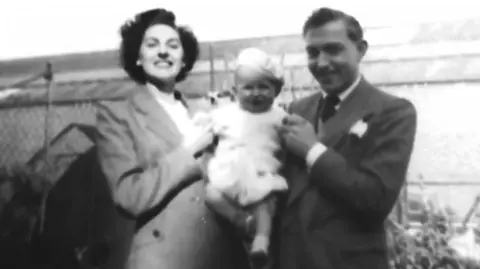 Supplied A black and white image of Reginald Jones, right, and a woman, left holding a baby between them.