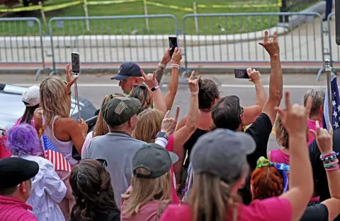Getty Images People hold their fingers in air to make the American Sign Language for "I love you"