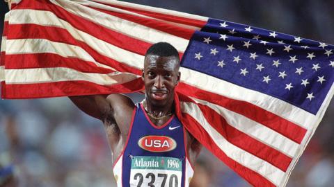 Michael Johnson celebrates with an American flag