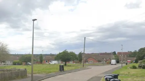 Google A street view of St Austell Road in Leicester, showing a grey road, lined by grass verges and houses