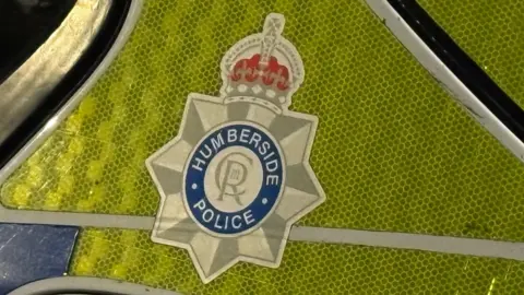 BBC A Humberside Police logo on the side of a police car.
