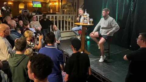 Oliver Conopo/BBC Kyren Wilson on stage with his trophy at Barratts