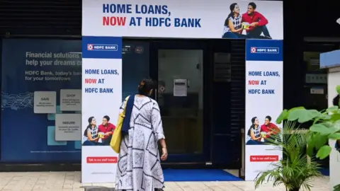 Getty Images A woman is seen walking into a bank in Mumbai.