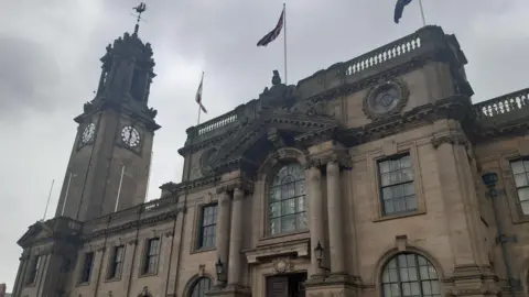 South Shields Town Hall, an elaborate and elegantly designed building with tall windows, carved pillars, and a sculpted depiction of a knight atop an arched roof.