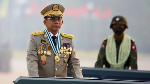 Min Aung Hlaing in military uniform with an unidentifiable soldier behind him