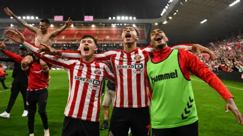 Chris Rigg, Jobe Bellingham and Wilson Isidor celebrate Sunderland reaching the play-off final