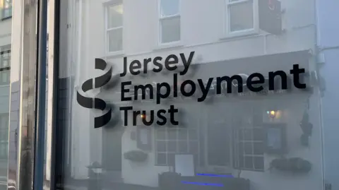 The Jersey Employment Trust sign is emblazoned on a window in black text.