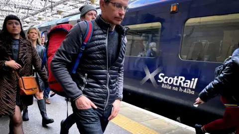 PA Media ScotRail bid     with passengers walking past