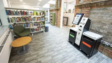 Wokingham Borough Council A room in the library with modern wooden floors but exposed brick walls