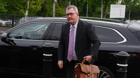 A man in a suit getting out of a car 