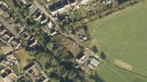 A 2007 satellite image of the site located in Innerleith near the Scottish Borders. The site is in the centre of the image with houses around it. There does not appear to be much on it.