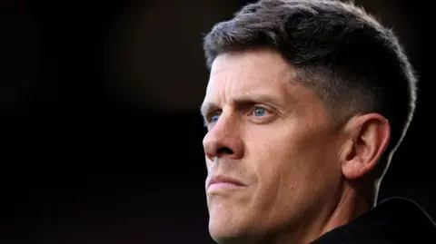 A close-up of Alex Revell in front of a black background