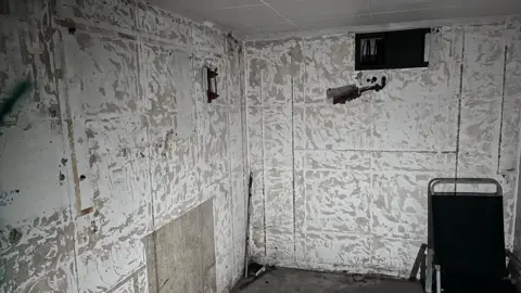 Phil Harrison/BBC The inside of a bunker, with white walls.