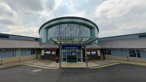 Google Lanchester Road Hospital's main entrance. It it a two-storey building with a large round atrium behind the front door.