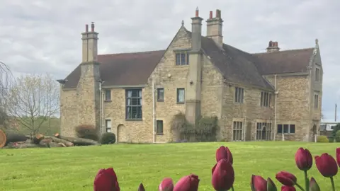 South Kesteven District Council A image of Fulbeck Manor, a stately home, with tulips in the foreground.