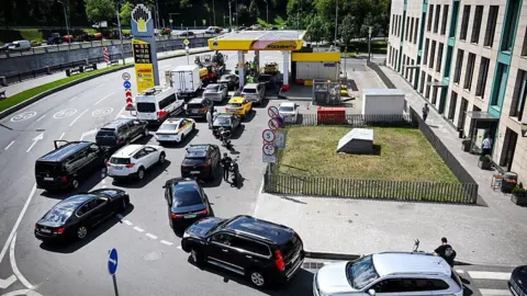 People queue to refuel their cars at a Rosneft gas station in Moscow 
