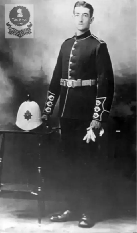 Wendy Sadler A black and white picture of a young man in navy uniform standing next to his hat on a table