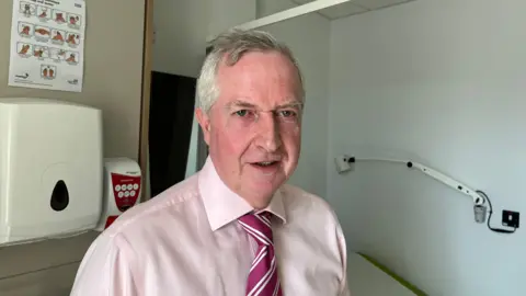 Dr David Griffith in a medical room with a shirt and tie on.