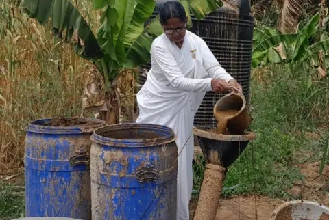 Rukmini Kumbhar Rukmini Baburao Kumbhar pours slurry into a pipe