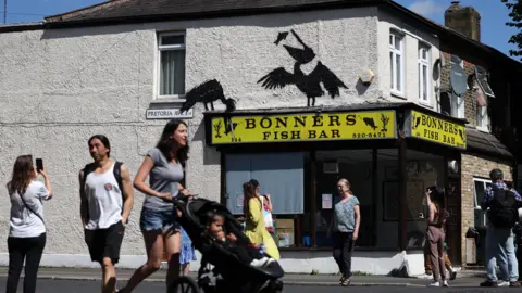 EPA people walk past Bonner's fish and chip shop