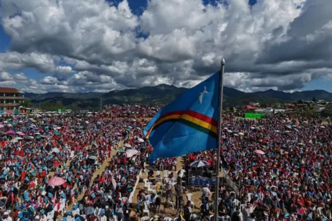Pessoas da AP agitando a bandeira Naga esperam pela chegada de Muivah na semana passada