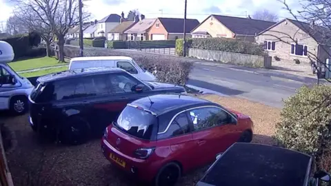 A view from a home in Christchurch, Cambridgeshire, showing cars in the foreground and a road 