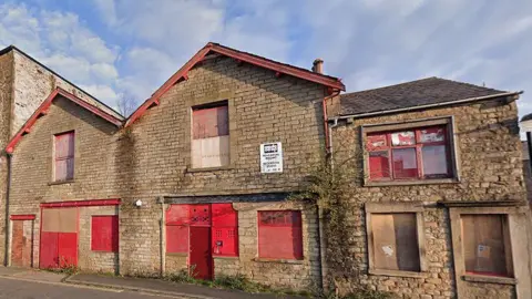 Google Empty building on Lodge Street, Lancaster, boarded up with red doors and shutters on the windows