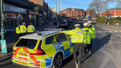 Several police officers and police car at the scene after three people were hit by a car in Main Street, Bulwell.
