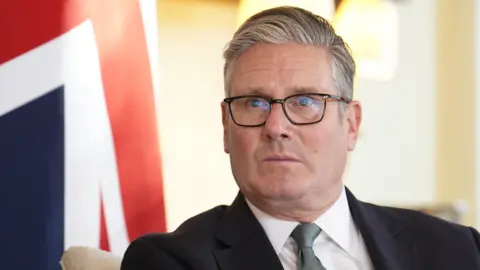 Sir Keir Starmer sits in front of a Union Jack 