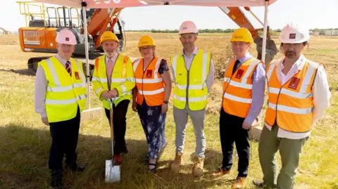 Leicestershire County Council A line-up of six people in high-vis PPE. One holds a spade