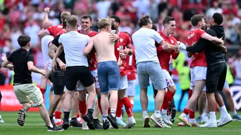 Getty Images Bristol City players and fans hug each other on the pitch after the 2-2 draw with Preston clinched a top six place for the club