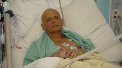 Getty Images Alexander Litvinenko lying successful  a infirmary  furniture  connected  an intensive attraction   unit. Lots of wires are linked up   to his chest. He has a bandage connected  1  hand. He is looking into the camera with a blank look  connected  his face. 