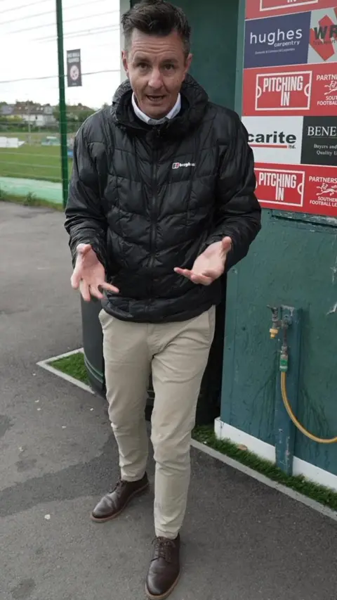 Andy stood in front of a football pitch