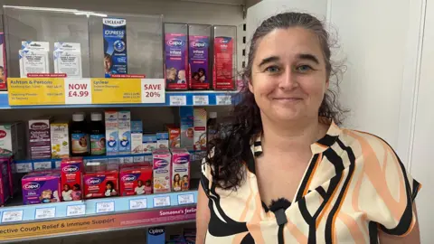 Yvonne Lamb represents community pharmacies in Somerset and is standing in front of medication at a practice in Brunham-on-Sea.