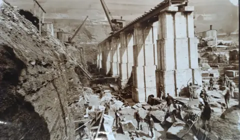 Severn Trent A black and white image showing a large column being constructed, with cranes also in shot and workers.