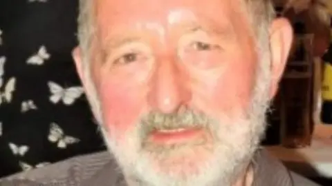 North Yorkshire Police A bearded man smiling at the camera. His facial hair is white.