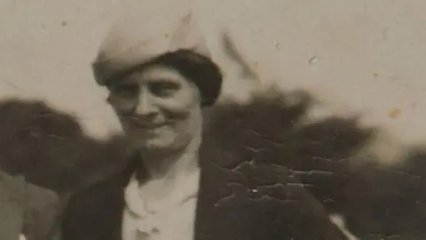 PA Media Black and white image of Louisa Dunne. It is an old and soft focused photo. She has dark hair tied back and is wearing a light-coloured hat and dark coat.