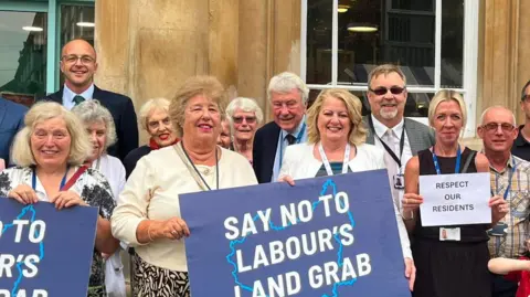 People holding placards saying "Say not to Labour's Land Grab." 
