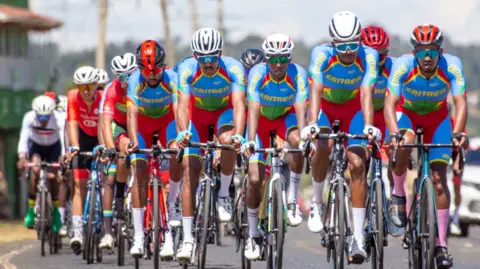 Six Eritrean cyclists ride at the head of a peloton during a race in Eldoret, Kenya